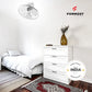 Modern bedroom with white bed and dresser, Formost fan, and 'Made in India' badge.