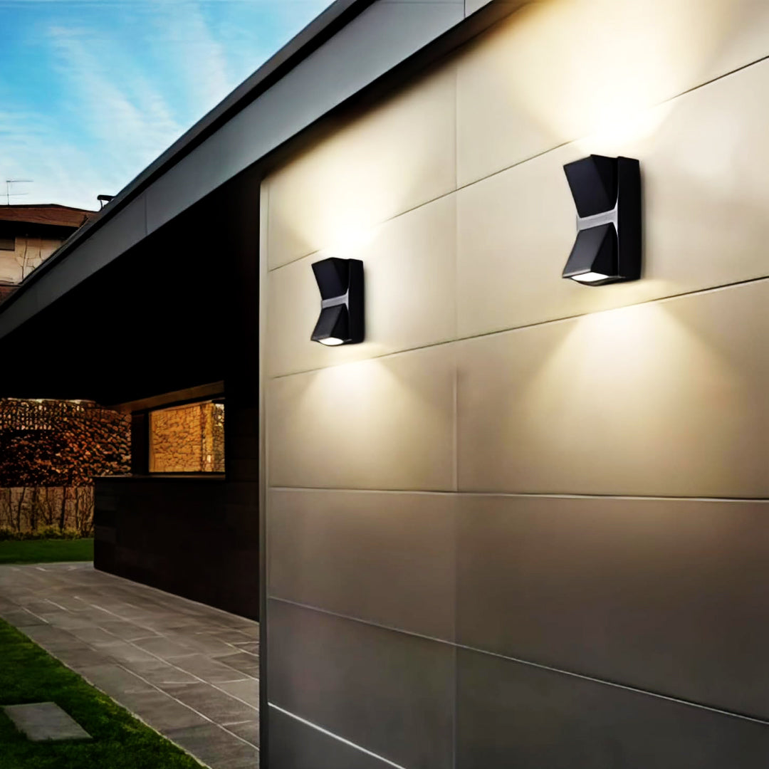 Modern outdoor wall lights on a house exterior with a clear sky.