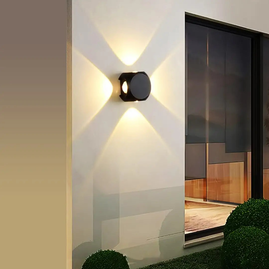 Modern outdoor wall light fixture on a building exterior with a view of a room inside.